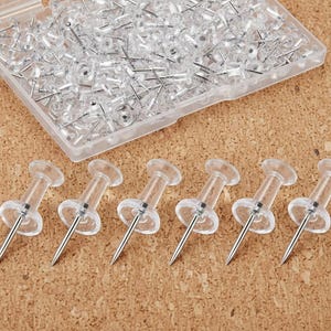 200 tachinhas transparentes com ponta de aço para fixação na parede.