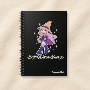 Può includere: Quaderno nero a spirale con un'illustrazione di una strega dei cartoni animati. Il testo "Soft Witch Energy" e il nome "Samantha" sono anch'essi visibili. La strega indossa un abito viola e un cappello arancione.