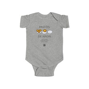 May include: A grey baby bodysuit featuring the words "PASTÉIS DE NADA" in black, with illustrations of pastries and a plate. The text "OPTIONAL PERSONALIZED TEXT HERE" is also printed on the bodysuit.