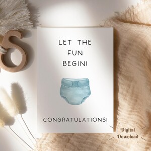Può includere: Una carta bianca con il testo nero « LET THE FUN BEGIN! » e « CONGRATULATIONS! ». Un'illustrazione ad acquerello di un pannolino blu è al centro. Le parole « Digital Download » sono nell'angolo in basso a destra.