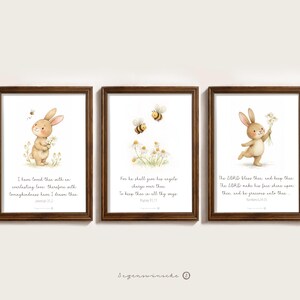 Könnte beinhalten: Set aus drei gerahmten Kunstdrucken mit Aquarellillustrationen eines Hasen und Bienen. Jeder Druck hat einen braunen Holzrahmen und enthält inspirierenden Text. Der Hase hält in zwei der Drucke Blumen.