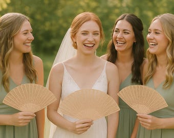 Könnte beinhalten: Vier lächelnde Personen, darunter eine Braut, halten offene Holzfächer. Die Fächer sind hellbraun und haben ein detailliertes, durchbrochenes Design. Die Frauen tragen hellgrüne Kleider und ein weißes Brautkleid.