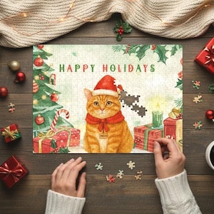 May include: A completed jigsaw puzzle with a festive cat wearing a Santa hat and scarf, with the words "Happy Holidays". The puzzle features a Christmas tree, gifts, and a lit candle. The image is on a wooden surface.