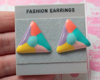 Könnte beinhalten: Ein Paar dreieckige Ohrringe mit einem geometrischen Muster in den Farben Rosa, Gelb, Lila, Türkis und Blaugrün. Die Ohrringe werden auf einer weißen Karte mit dem Text "FASHION EARRINGS" präsentiert.