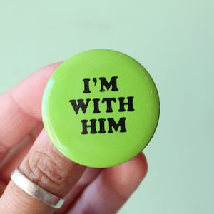 May include: A green button with the text "I'M WITH HIM" in black letters.