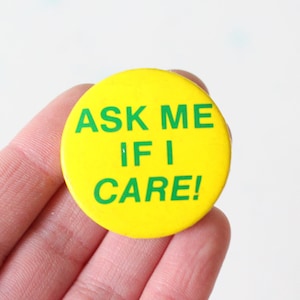 May include: A yellow button with green text that reads "ASK ME IF I CARE!"