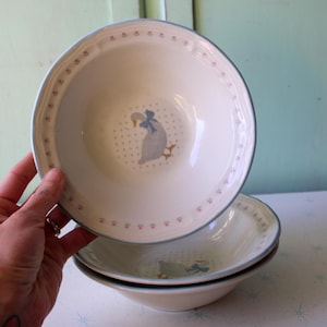 May include: Three white ceramic bowls with a blue and pink floral pattern and a blue and white goose design. The bowls are stacked on top of each other.