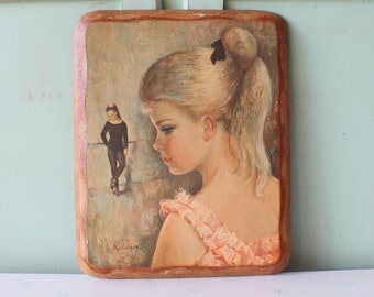 May include: A framed vintage painting of a young girl with a ponytail, wearing a pink dress, looking to the side. A smaller figure of a girl in a black leotard is visible in the background.