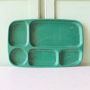 Op de afbeelding: Een groene, verdeelde dienblad van plastic met vijf vakken. Het dienblad is ontworpen om voedsel te serveren.