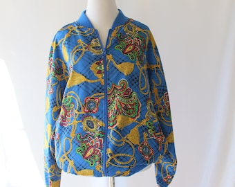May include: A blue bomber jacket with a paisley and rope pattern. The jacket has a zipper closure and long sleeves.