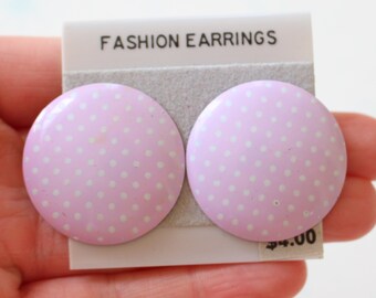 Könnte beinhalten: Ein Paar runde Ohrringe mit rosa und weißen Punkten. Die Ohrringe haben eine glänzende Oberfläche. Die Ohrringe sind mit "Fashion Earrings" und "4,00 €" beschriftet.