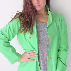 May include: A bright green blazer with a collar and two yellow buttons. The blazer is made of a lightweight fabric and has a relaxed fit.