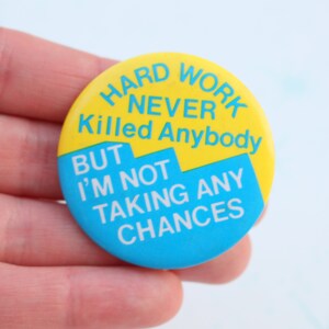 May include: A yellow and blue button with the text "Hard Work Never Killed Anybody But I'm Not Taking Any Chances".