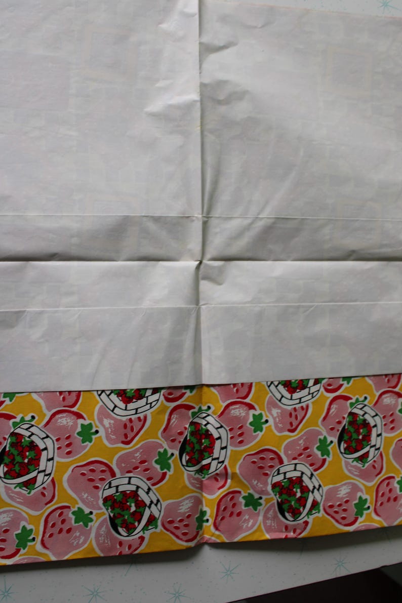 May include: A white sheet of paper with a yellow and pink border. The border has a repeating pattern of pink strawberries with green leaves and red centers in a white basket on a yellow background.