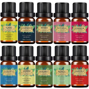 Puede incluir: Una colección de once botellas de vidrio ámbar de aceites esenciales con tapas negras. Cada botella tiene una etiqueta con un nombre de aceite esencial diferente, incluyendo Ylang, Lavanda, Mirra, Pachulí, Geranio, Eucalipto, Jazmín, Bergamota, Neroli y Pomelo. Cada botella contiene 10 ml.