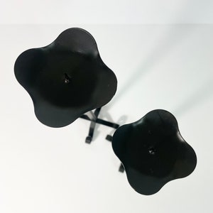 Pode incluir: Casti&ccedil;al de metal preto com duas ta&ccedil;as para velas em forma de flor. O casti&ccedil;al &eacute; projetado para segurar duas velas.