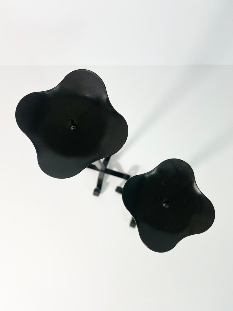 Pode incluir: Casti&ccedil;al de metal preto com duas ta&ccedil;as para velas em forma de flor. O casti&ccedil;al &eacute; projetado para segurar duas velas.