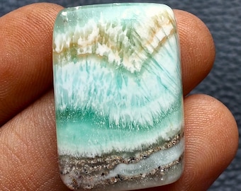 May include: A rectangular polished gemstone featuring a smooth surface with a vibrant color palette of mint green, white, and earthy brown. The stone displays intricate, layered patterns with crystalline textures and distinct horizontal bands.