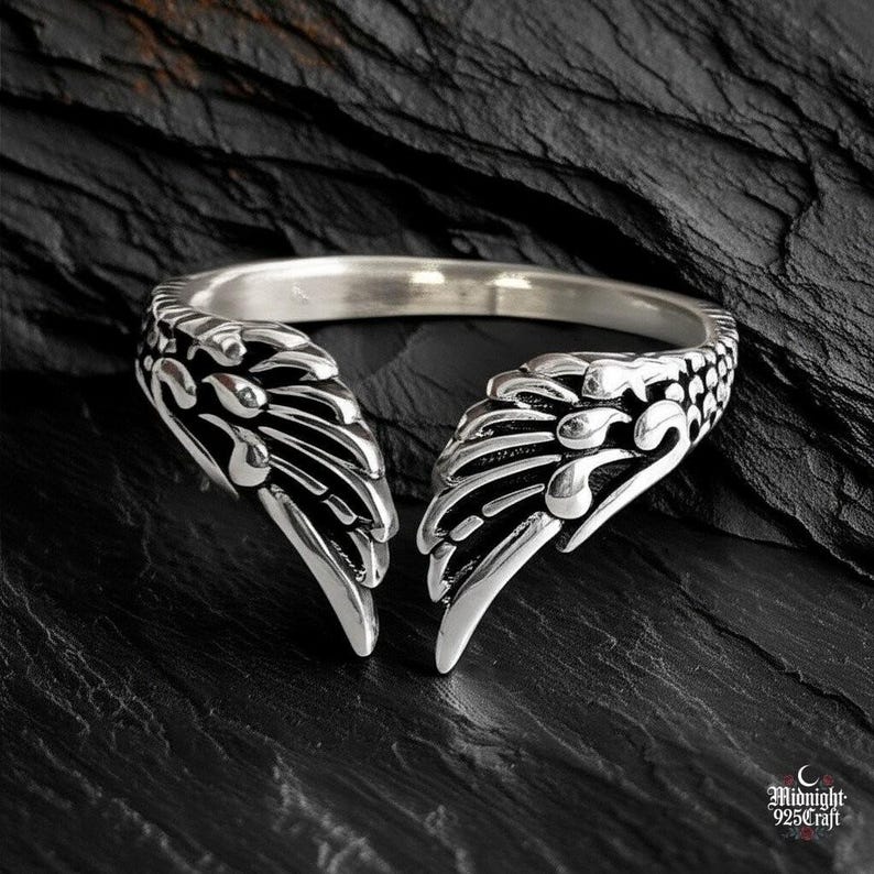 Interior view of gothic angel wing ring showing S925 sterling silver hallmark and adjustable band construction. Smooth polished interior contrasts with detailed exterior wing design. Comfortable fit, hypoallergenic silver, perfect for daily wear. Gothic fashion accessory for alternative style enthusiasts.
