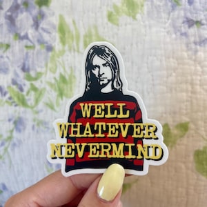 May include: A sticker featuring a black and white image of a person with long hair, wearing a red and black striped shirt. The sticker has the text "WELL WHATEVER NEVERMIND" in yellow.
