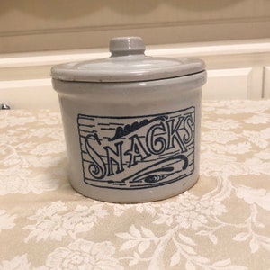 May include: A white ceramic jar with a blue lid and a blue design that says "SNACKS".