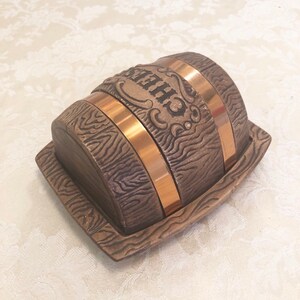 May include: A wooden barrel-shaped butter dish with a copper band and the word "CHIPS" embossed on the top.