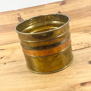 May include: A white ceramic mug with a black handle and the text "But First, Coffee" in a black, handwritten-style font. The mug is on a white surface.