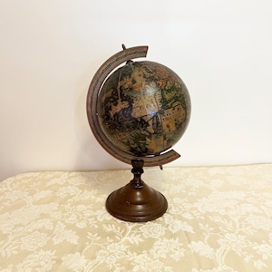 May include: A vintage-style globe with a brown wooden base and a metal stand. The globe features a detailed map of the world with a faded, antique look.