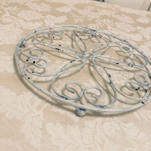 White Metal Trivet Footed Metal Pot Holder Dinner Serving Table Protection From Heat Also A Decorative Trivet Holding a Unique Teapot Trivet