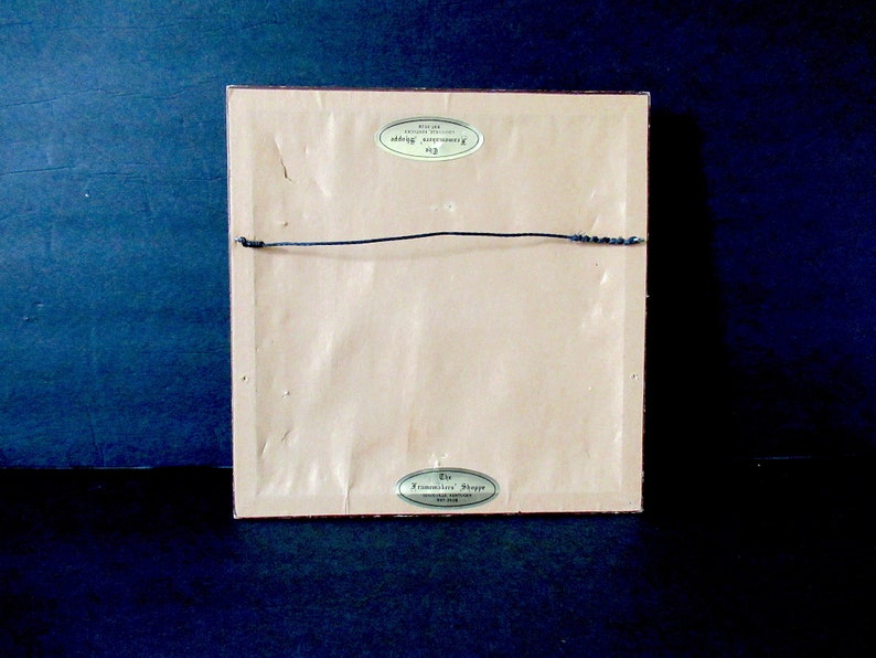 May include: The back of a framed print with a gold label that reads "The Commemorative Paper", and a smaller gold label that reads "The Commemorative Paper, Inc."
