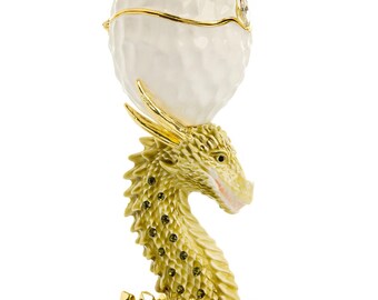 Huevo blanco con cabeza de dragón dorado