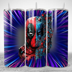Puede incluir: Tres vasos de acero inoxidable con pajitas. Cada vaso presenta un dise&ntilde;o de rostro dividido del personaje Deadpool, con esquemas de color rojo y azul. El fondo tiene un patr&oacute;n de r&aacute;faga radial en tonos de morado y azul. Adecuado para bebidas fr&iacute;as.