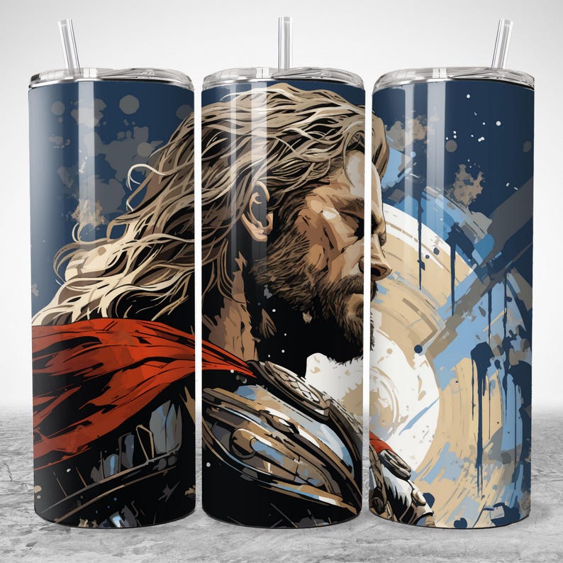 Puede incluir: Un vaso de acero inoxidable con una ilustraci&oacute;n estilizada de un guerrero con pelo largo y rubio, barba y capa roja. El dise&ntilde;o incluye un fondo azul con salpicaduras de pintura y un escudo. El vaso tiene una pajita transparente.