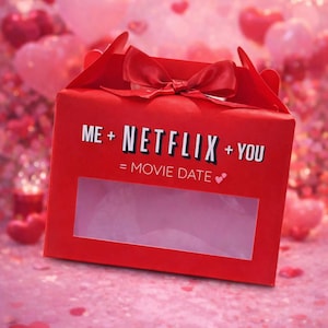 Puede incluir: Una caja de regalo roja con una ventana transparente, un lazo rojo y el texto "ME + NETFLIX + YOU = MOVIE DATE" en blanco. El fondo presenta globos y confeti en forma de corazón rosa y rojo.