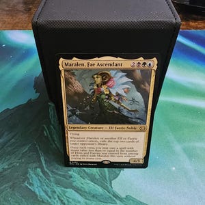 Può includere: Una scatola nera per riporre carte con una carta Magic: The Gathering all'interno. La carta presenta l'artwork di Maralen, Fae Ascendant, un leggendario Elf Faerie Noble. La carta ha una forza e resistenza di 4/5.