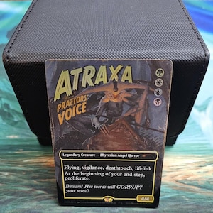 May include: A Magic: The Gathering trading card titled Atraxa, Praetors' Voice, featuring a dark, illustrated creature with wings. The card text includes 'Flying, vigilance, deathtouch, lifelink' and 'At the beginning of your end step, proliferate.'