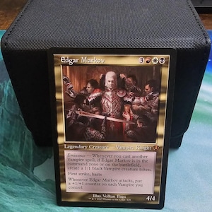 May include: A Magic: The Gathering trading card featuring the legendary creature Edgar Markov, a Vampire Knight. The card displays a gold border, the name Edgar Markov, mana costs, and detailed game text including Eminence, first strike, and haste.