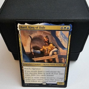 May include: A Magic: The Gathering trading card titled Bard, King of Dale, featuring a gold-clad archer with a crown. The card text includes Reach, vigilance, and abilities related to drawing cards and creating tokens, with a power and toughness of 3/5.