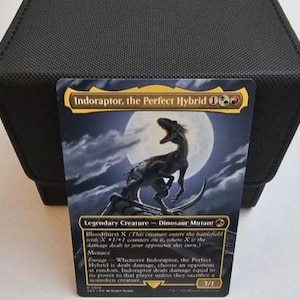 May include: A Magic: The Gathering trading card titled Indoraptor, the Perfect Hybrid, featuring a dinosaur illustration against a full moon. The card text includes Bloodthirsty X, Menace, and Enrage abilities, with a power and toughness of 3/1.