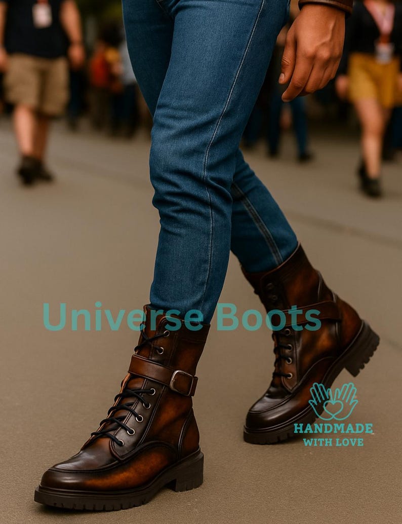 May include: Brown leather boots with a buckle and lace-up design. The boots have a rugged sole and are worn with blue jeans. The text "Universe Boots" and "HANDMADE WITH LOVE" are visible.