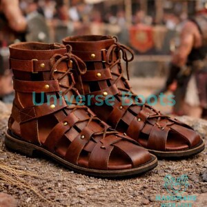 Op de afbeelding: Bruine leren gladiatorsandalen met veters en riemen. De sandalen hebben een versleten uitstraling, met stiksels en metalen klinknagels. Het schoeisel is ontworpen met een open teen en hiel.