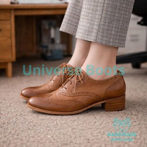 May include: Brown leather brogue shoes with a low block heel. The shoes have decorative perforations and lace-up closures. The text "Universe Boots" is visible in the image.
