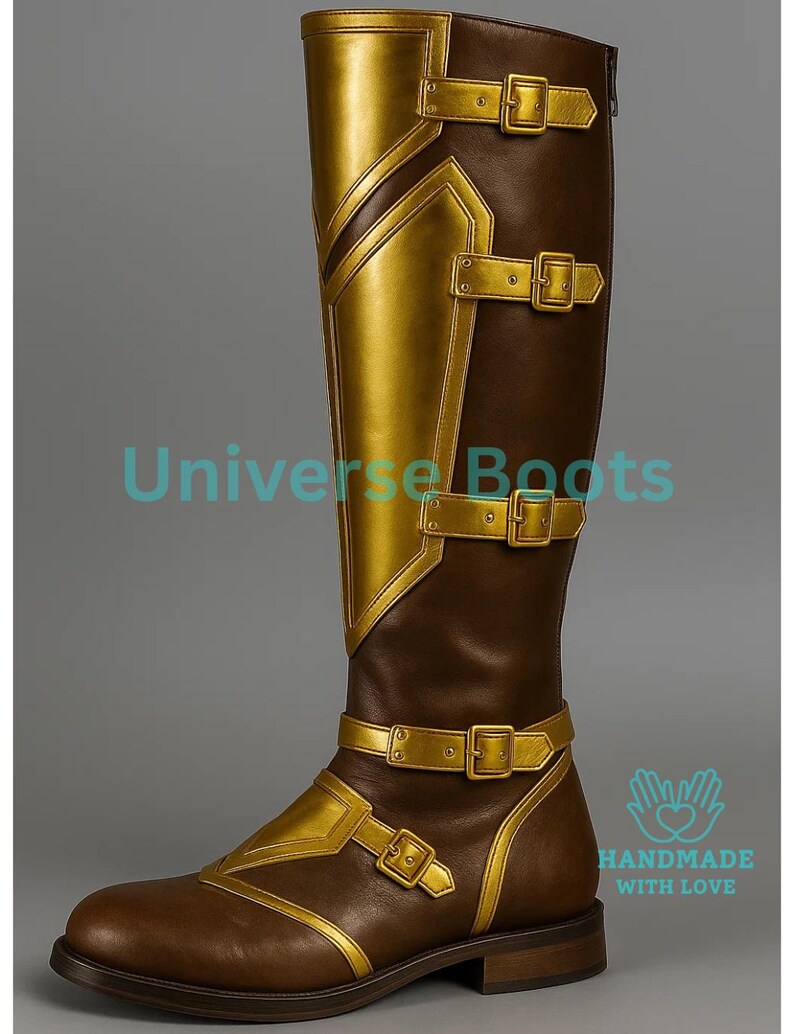 May include: Brown and gold knee-high boot with buckle details. The boot features gold accents on the front and sides, with multiple buckles and straps. The boot has a zipper on the back and is labeled "Universe Boots" and "Handmade with Love".