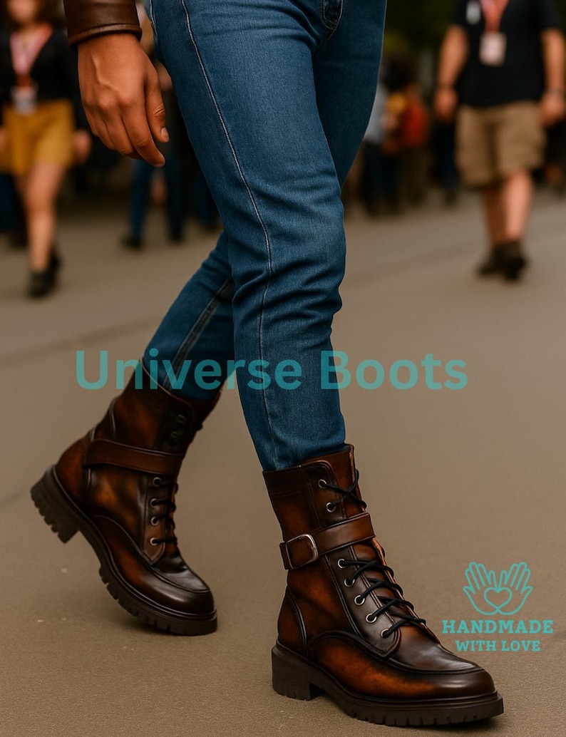 May include: Brown leather boots with a buckle and lace-up design. The boots have a chunky sole and are worn with blue jeans. The text "Universe Boots" is visible. The boots are handmade with love.