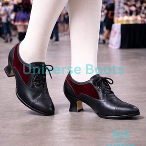 May include: Black and burgundy lace-up shoes with a small heel. The shoes have a leather appearance with a burgundy velvet panel. The text "Universe Boots" is visible on the image.
