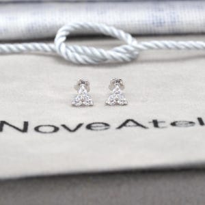 May include: A set of three ceramic mugs with a speckled, matte finish. The mugs are in shades of cream, light gray, and dark gray. Each mug has a simple, minimalist design, perfect for coffee or tea.