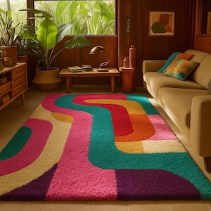 May include: A brightly coloured, retro-style rug with a wavy pattern. The rug features a vibrant mix of colours, including pink, purple, teal, red, orange, and yellow. The rug is placed in a living room setting with a sofa and wooden furniture.