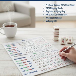 May include: A guide for American Mahjong 2025, with the text "2025 AMERICAN MAHJONG HANDS GUIDE - INSTANT DOWNLOAD." The guide includes a cheat sheet, hands, beginner help, and card reference. A hand is holding a pen, and a cup of tea is on the table.