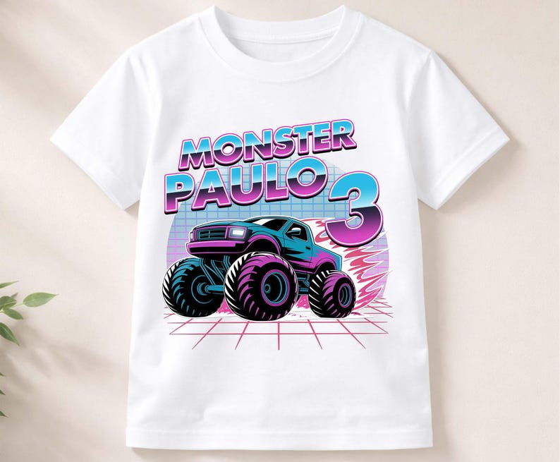 Puede incluir: Camiseta blanca con un gr&aacute;fico colorido de un monster truck y el texto "MONSTER PAULO 3". El dise&ntilde;o incluye un monster truck azul y morado con neum&aacute;ticos grandes, sobre un fondo retro.