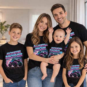 Puede incluir: Una familia viste camisetas negras a juego con un dise&ntilde;o de monster truck. Las camisetas dicen "Monster Brother", "Monster Mom", "Monster Paulo" y "Monster Sister". El dise&ntilde;o presenta un monster truck en tonos azules, rosas y morados con un fondo retro.